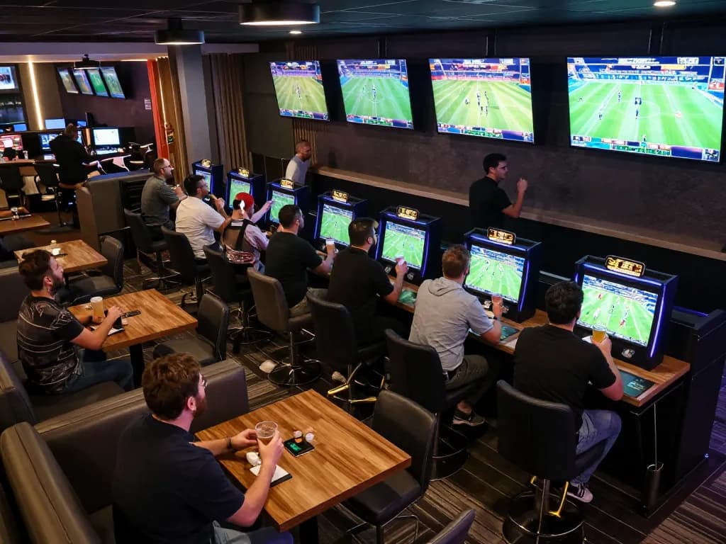 Patrons strategizing their bets at 789win's dynamic sports betting lounge, excited atmosphere.